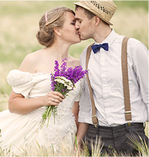 bride and groom kissing in a field